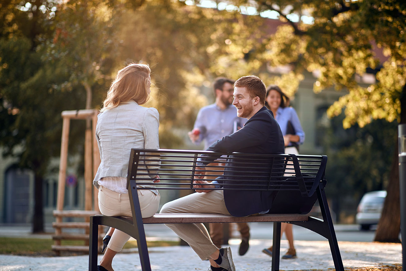People meeting outside on a bench in a park